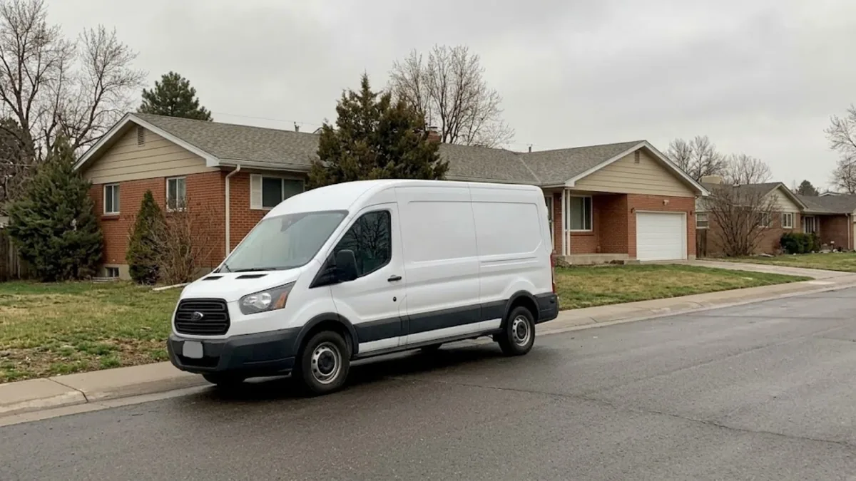 Unmarked plumbing service van parked in front of a Thornton home