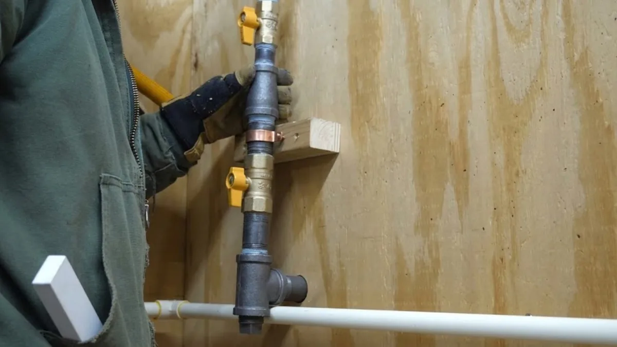 Black iron gas line with shutoff valves being installed