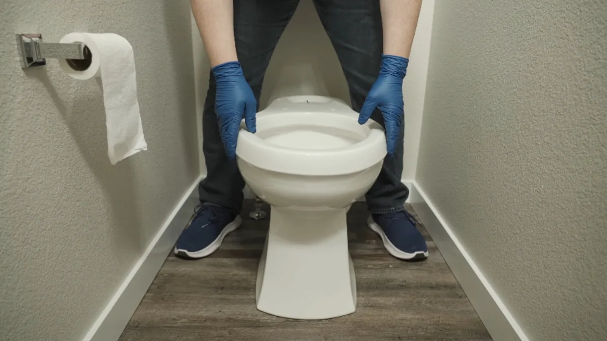 Plumber installing a new toilet in a residential bathroom