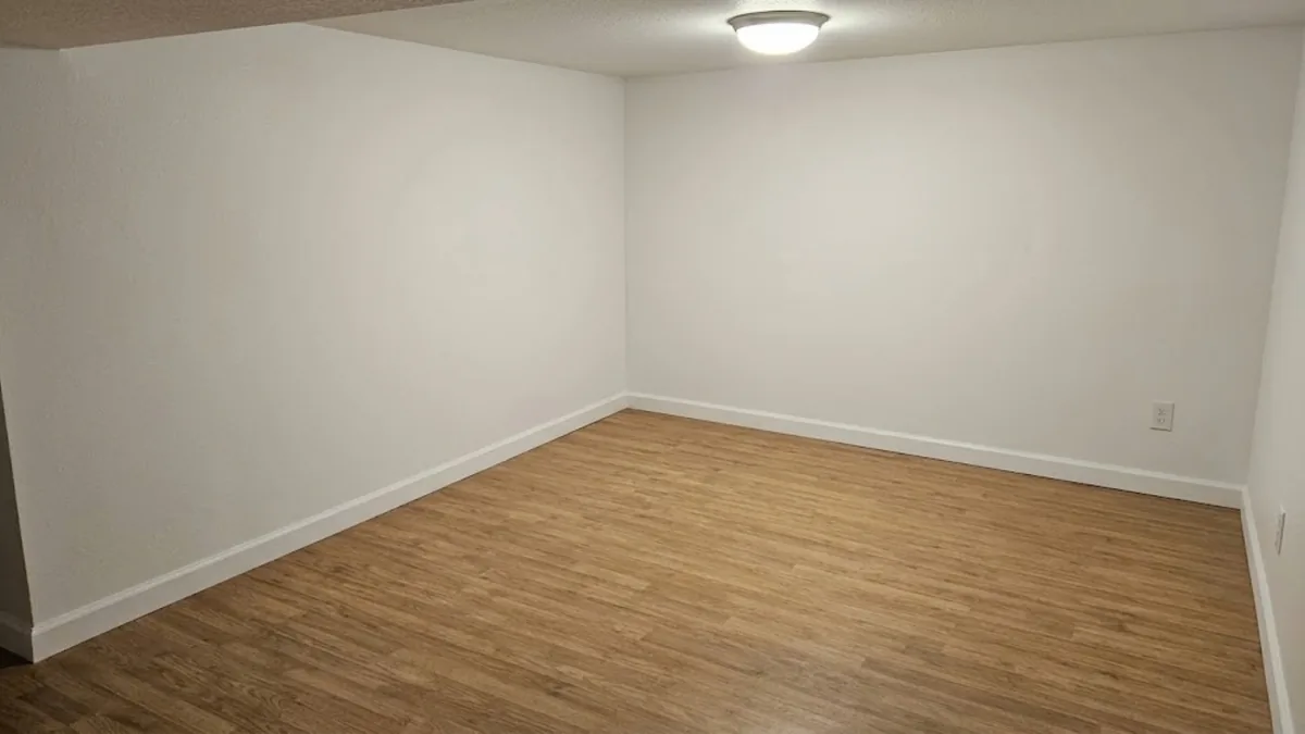 Same room fully restored with new flooring and drywall after water damage repair