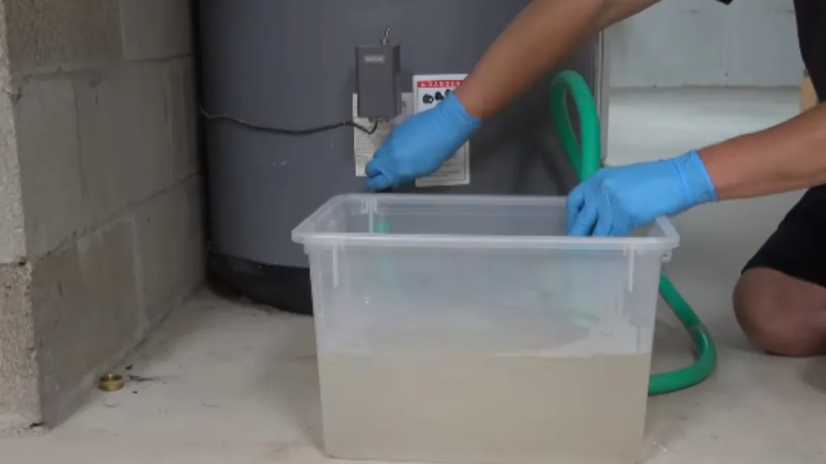 Plumber flushing sediment from a residential tank water heater