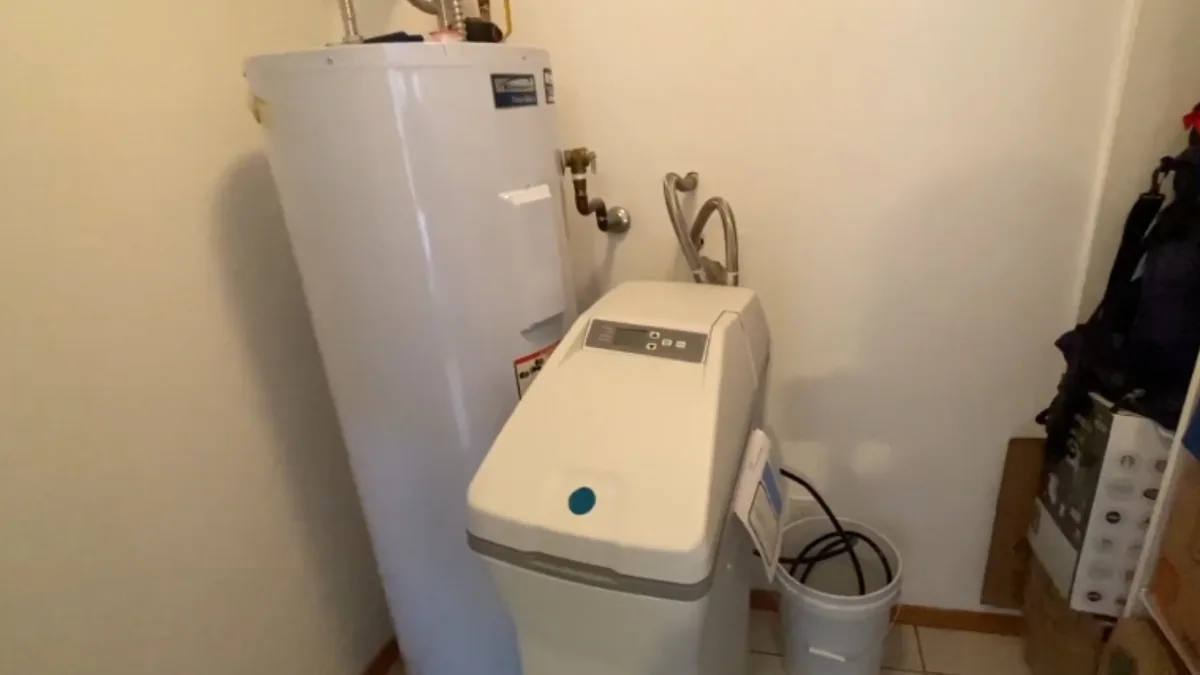 Water softener system installed beside a residential water heater